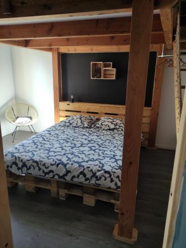 a bedroom with a bed with a wooden frame at Chez nono et vero in Roussillon en Isere