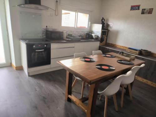 a kitchen with a wooden table and some chairs at Chez nono et vero in Roussillon en Isere