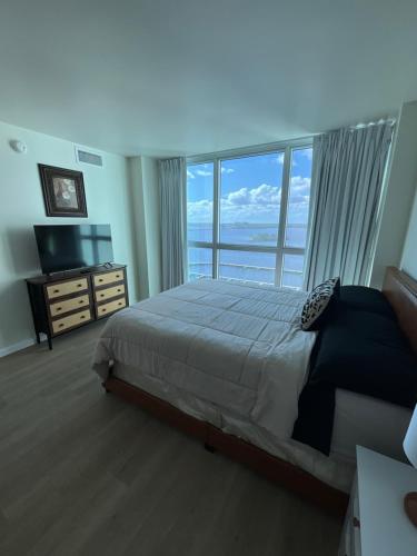 a bedroom with a bed and a large window at Stunning Water View Suite in Fort Myers
