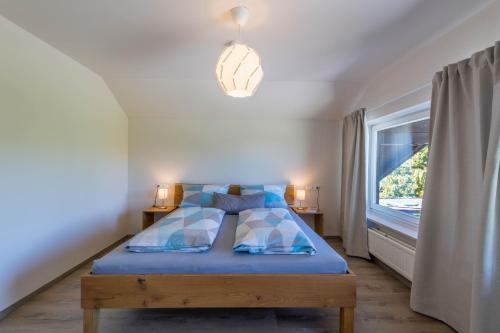 a bedroom with a blue bed and a window at Ferienwohnung Linde in Taching am See