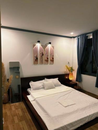 a bedroom with a large bed with white sheets at Sam's homestay in Ấp Bình Hưng