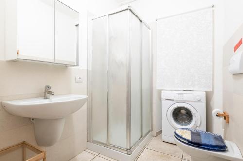 a bathroom with a sink and a washing machine at Appartamento Pini in Cala Gonone