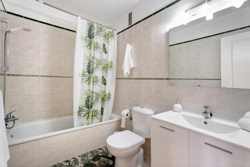a bathroom with a toilet and a sink and a tub at Sol y Mar in Puerto de Santiago