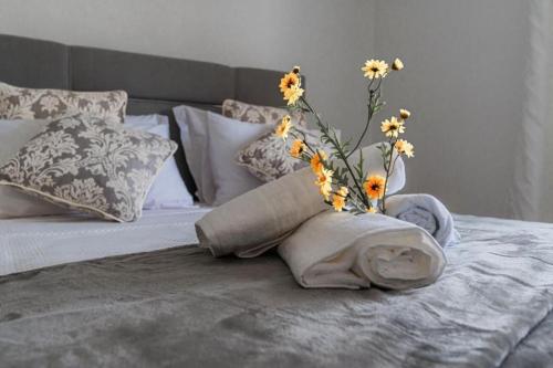 a bed with a vase with flowers on it at Sweet Home Madeira in Camacha