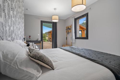 a bedroom with a large white bed and a window at Les loges de Pérelle in Chozeau
