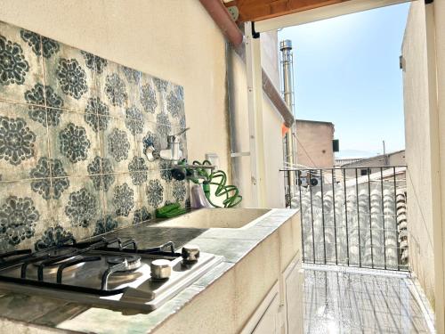 a kitchen with a stove top oven next to a balcony at Civico5 - Spazioso appartamento 110 mq a Cefalù in Cefalù