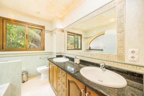 a bathroom with two sinks and a mirror at Villa Cala Llamp in Port d'Andratx