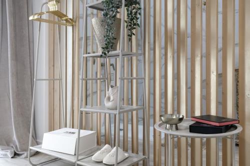 a three tier shelf with shoes and vases on it at Barsanz Palace Home in Alcalá del Valle