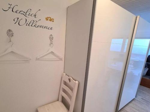 a chair sitting next to a wall with a sign on it at Chilli Home in Tettnang