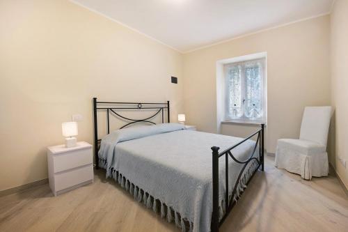 a bedroom with a bed and a chair and a window at Casa Vera Aurora Lake Garda in Torri del Benaco