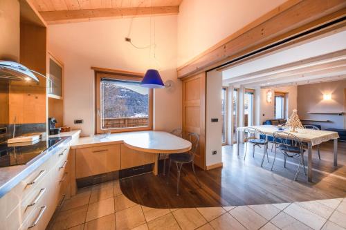 a kitchen with a table and a dining room at La Pratolina Attico in Castello di Fiemme