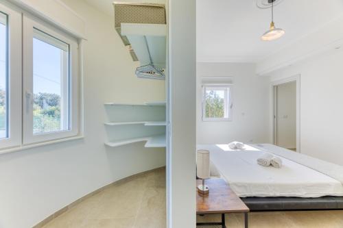 a white room with a bed and a table at Villa Bianca Appartament in Ugento