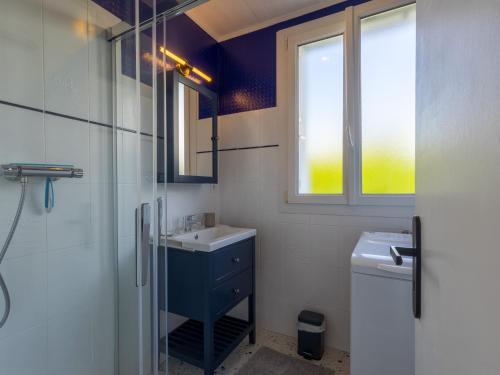 a bathroom with a sink and a toilet and a window at Petite Maison Cosy in Trégastel