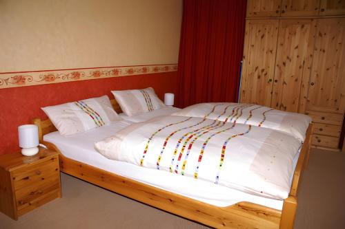 a bedroom with a large bed with white sheets at Haus Elke in Gomadingen