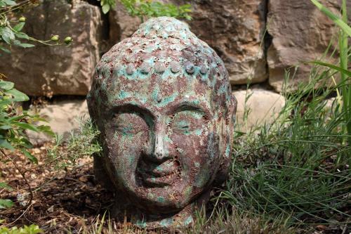 a statue of a head sitting in the grass at Lautertal Zinne in Hayingen