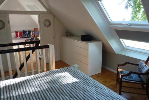 a attic room with a bed and a window at Feriencottage Nordseeluft in Siekbüll