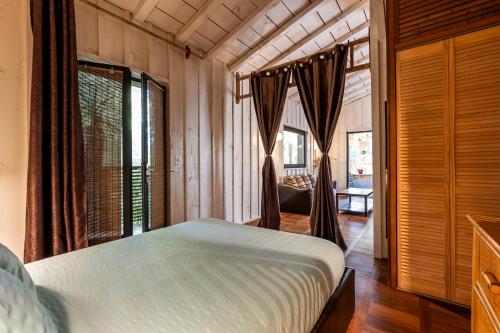 a bedroom with a bed in a room with windows at Chalet Savannaketh in Lacanau