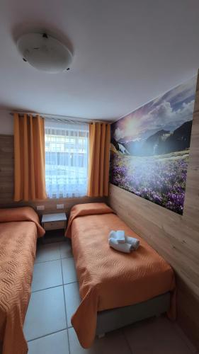 a bedroom with two beds and a painting on the wall at Night and day 3 in Predazzo