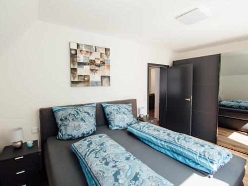 a living room with a couch with blue pillows at Die Gönothek - Ferienwohnungen in Iphofen