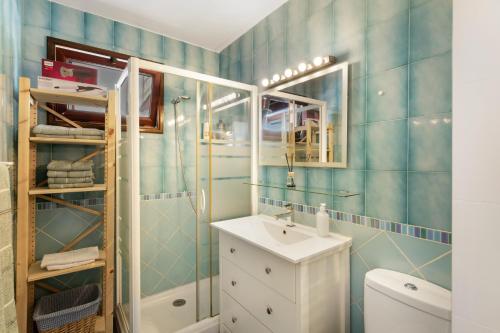 a bathroom with blue tiled walls and a sink at Olas De Plata in Playa del Hombre