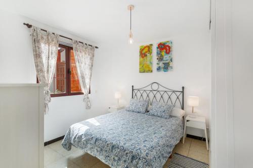 a white bedroom with a bed and a window at Olas De Plata in Playa del Hombre