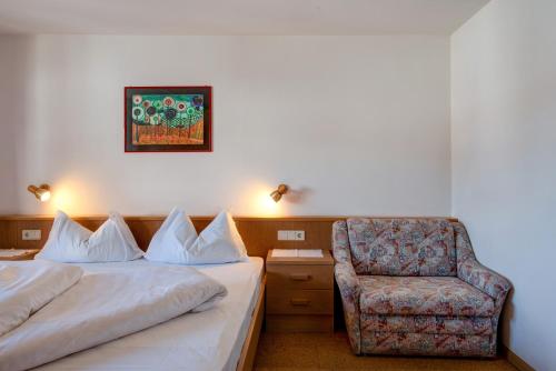 a hotel room with two beds and a chair at Apartment 5 - Zur Sonne in Laion
