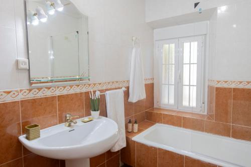 a bathroom with a sink and a tub and a mirror at Espacio Rural La Cabaña de Miraflores in Miraflores de la Sierra