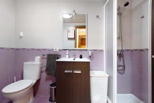 a bathroom with a toilet and a sink and a shower at Costamar Arinaga in Arinaga