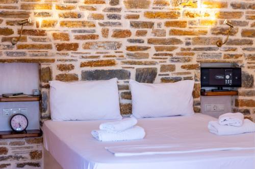 a bed in a room with a brick wall at Menagia Village in Agios Georgios
