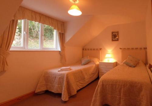 a bedroom with two beds and a window at Ysgubor Illtyd in Dolgellau