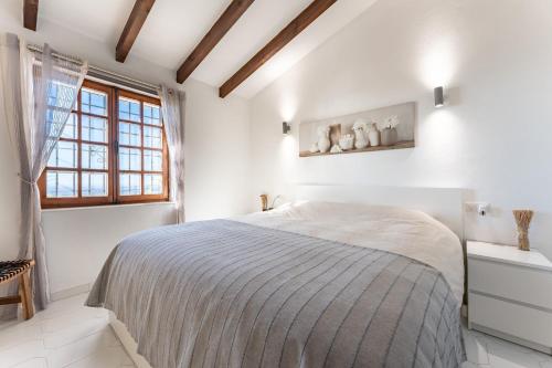a white bedroom with a bed and a window at Mijas la Nueva in Mijas