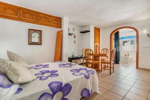 a bedroom with a bed and a dining room at La Finca Moraira in Teulada