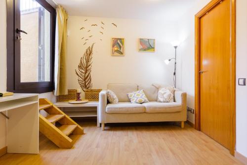 a living room with a couch and a window at Sauc Beach Apartment in Canet de Mar
