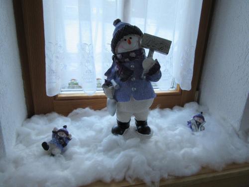 a stuffed snowman holding a sign on a pile of snow at Alpen-Chalet Ehrwald in Ehrwald
