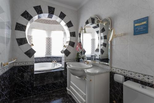 a bathroom with a sink and a toilet and a tub at Villa Nerja in Nerja