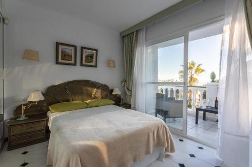 a bedroom with a large bed and a balcony at Villa Nerja in Nerja