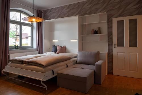 a bedroom with a bed and a chair and a window at Ferienwohnung Lindner 2 in Weimar