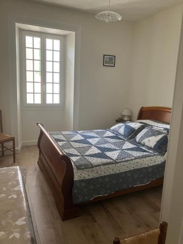 a bedroom with a bed with a blue and white quilt at Chez Bilhouet in Segonzac