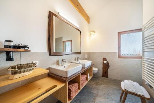 a bathroom with two sinks and a mirror at Seppnerhof Ferienwohnung Edelweiss in Moso