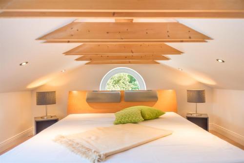 an attic bedroom with a large bed with a window at Appartement Halbinsel Wittow in Binz