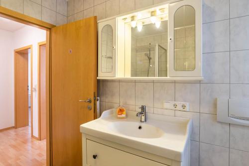 ein Badezimmer mit Waschbecken und Spiegel in der Unterkunft Aposto Apartments 2 in Oberderdingen