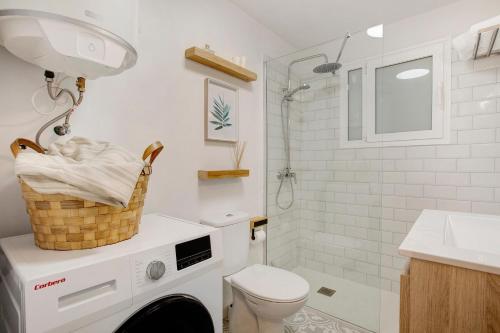 a bathroom with a toilet and a sink and a washing machine at Salitre Suites Tamara in Tacoronte