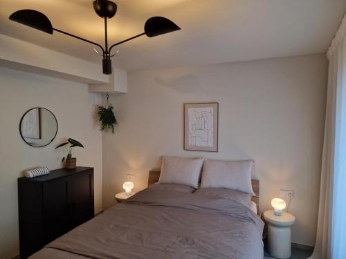 a bedroom with a bed with two lights on it at moselquartier terlinden- Apartment in Besch