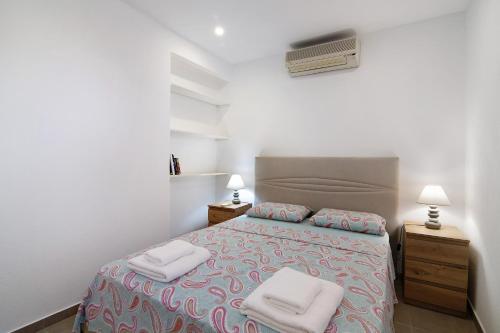 a bedroom with a bed with two towels on it at Adelino Guest House in Olhão