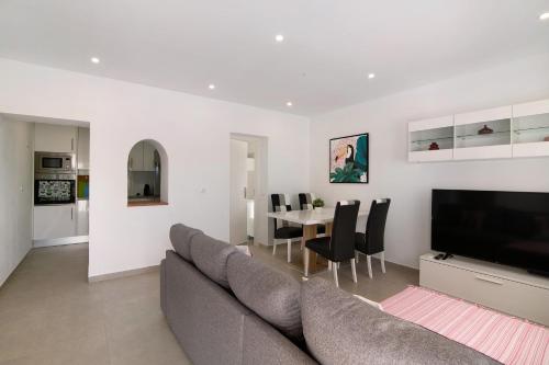 a living room with a couch and a table with chairs at Adelino Guest House in Olhão