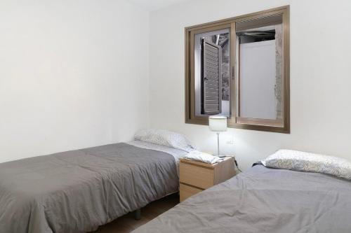 two beds in a room with a mirror and a window at Suite Deluxe Puerto Rico 11 in Puerto Rico de Gran Canaria