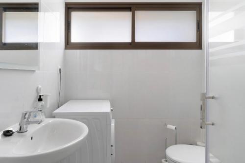 a white bathroom with a sink and a toilet at Suite Deluxe Puerto Rico 11 in Puerto Rico de Gran Canaria