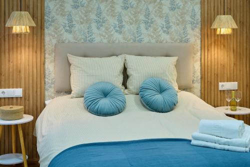 a bedroom with a bed with blue pillows on it at El Mirador de Neptuno in Priego de Córdoba