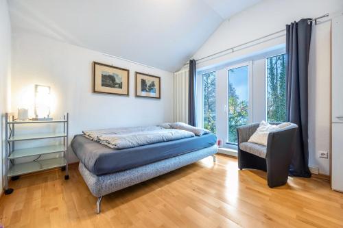 a bedroom with a bed and a chair and a window at Alter Laden in Nienstädt