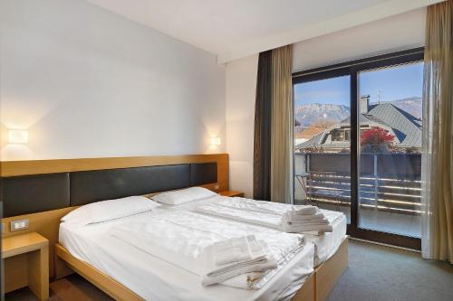 a bedroom with a bed and a large window at Residence Alpenrose in Col di Villa